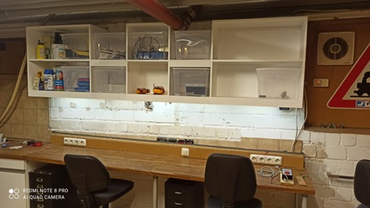 ein großzügiger Arbeitsplatz mit viel Stauraum in den Hängeregalen